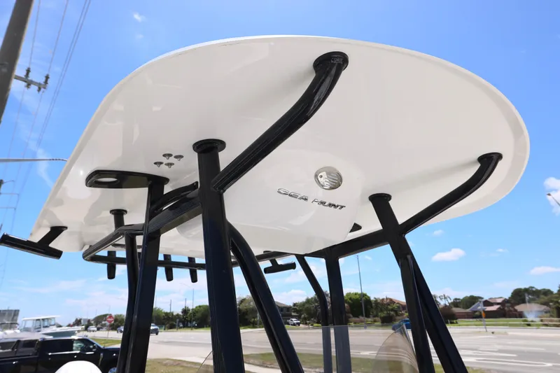 Slide: The Image of 2026 Sea Hunt Ultra 219 boat T-top structure under clear blue sky. - 11