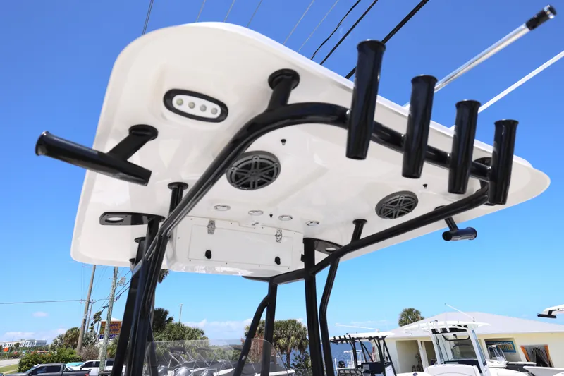 Slide: The Image of 2026 Sea Hunt Ultra 219 boat T-top with rod holders and speakers against blue sky. - 5