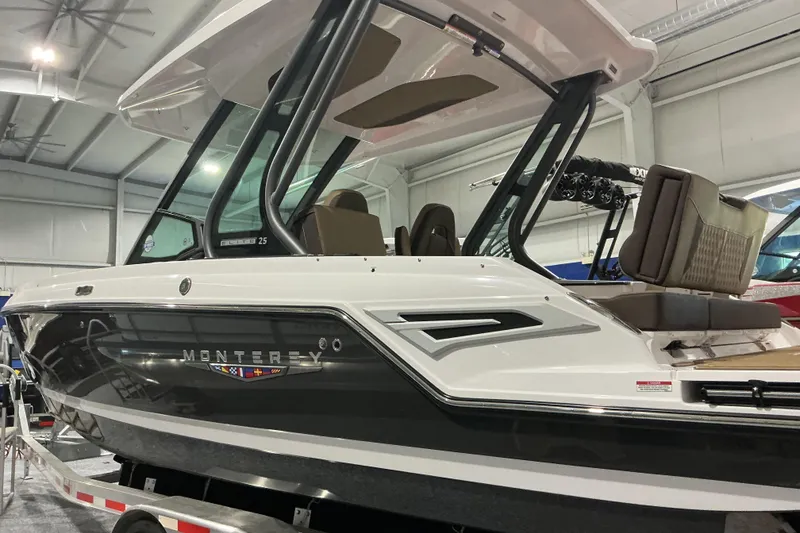 Slide: The Image of 2026 Monterey Elite 25 OB boat displayed indoors, showcasing sleek design and modern features. - 10