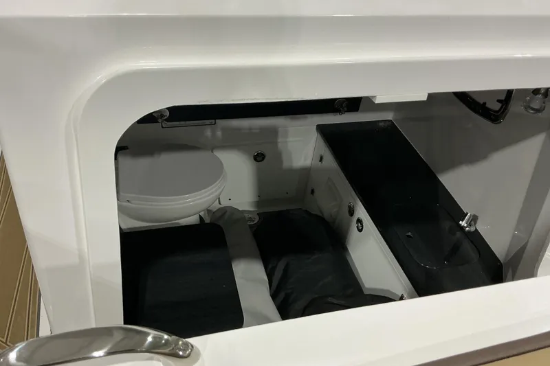 Slide: The Image of Interior cabin view of 2026 Monterey Elite 25 OB boat, featuring a compact toilet and sink. - 12