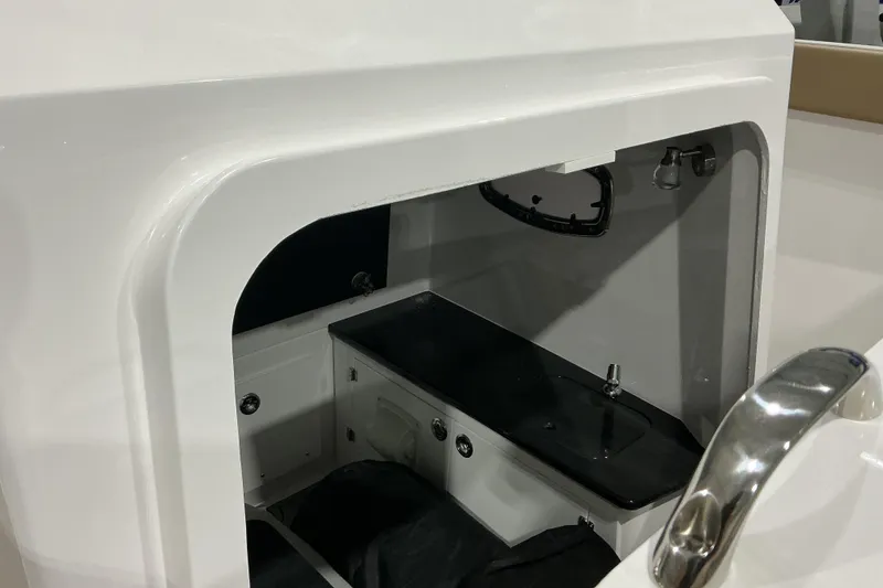 Slide: The Image of Interior view of 2026 Monterey Elite 25 OB boat cabin with sink and storage. - 13