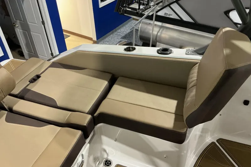Slide: The Image of 2026 Monterey Elite 25 OB boat interior with beige seating and cup holders. - 16