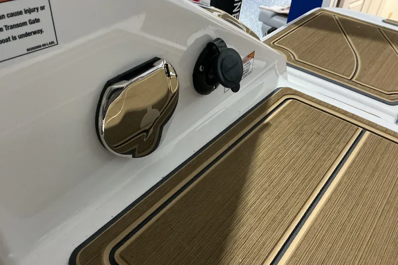 Slide: The Image of 2026 Monterey Elite 25 OB boat deck with wood finish and chrome details. - 18
