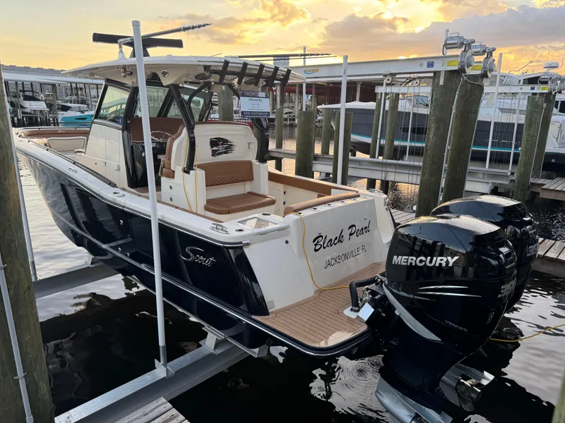 Slide: The Image of 2021 Scout 330 LXF boat docked with twin Mercury engines at sunset. - 44