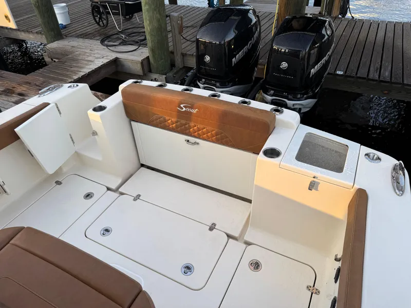 Slide: The Image of 2021 Scout 330 LXF boat interior with twin Mercury engines at dock. - 76