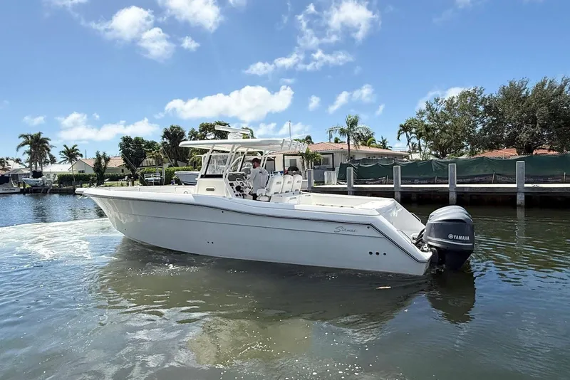 Slide: The Image of 2014 Stamas 390 Tarpon boat on water, clear sky, palm trees in background. - 10