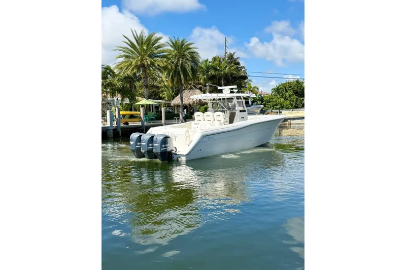 Slide: The Image of 2014 Stamas 390 Tarpon boat with triple engines on a sunny day near palm trees. - 12