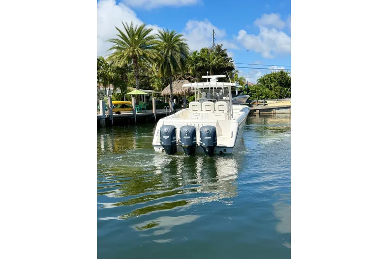 Slide: The Image of 2014 Stamas 390 Tarpon boat with triple engines on a sunny day near a dock. - 13