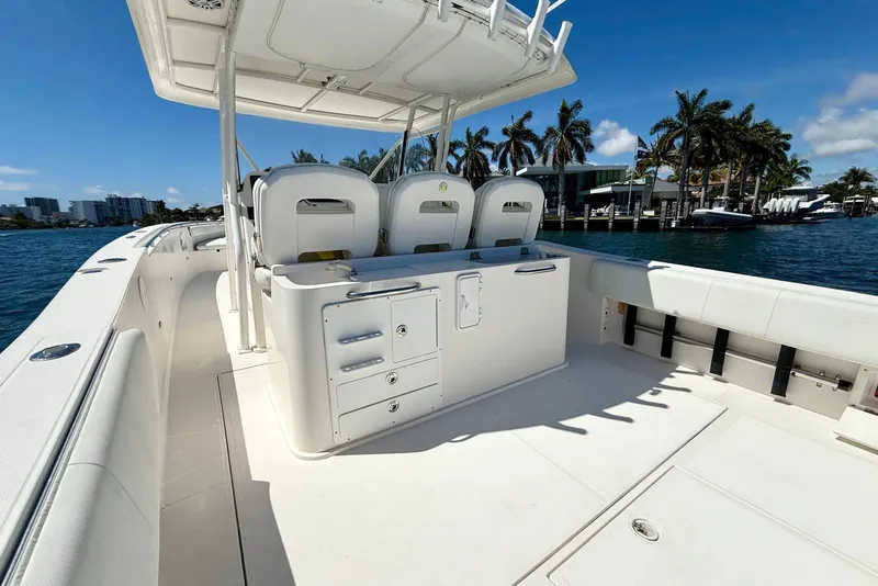 Slide: The Image of 2014 Stamas 390 Tarpon boat interior with seating and storage, docked near palm trees. - 24