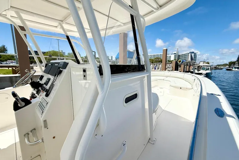 Slide: The Image of 2014 Stamas 390 Tarpon boat docked, showcasing helm and seating area under clear blue sky. - 33