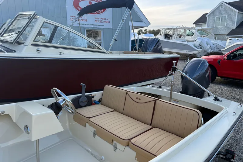 Slide: The Image of 2026 Rossiter 14 boat with beige seating and Yamaha outboard motor in a marina setting. - 4