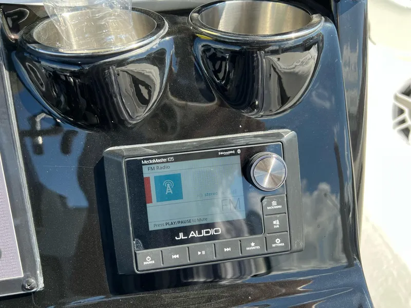 Slide: The Image of JL Audio system on 2023 Tidewater 320 CC Adventure boat dashboard with cup holders. - 10