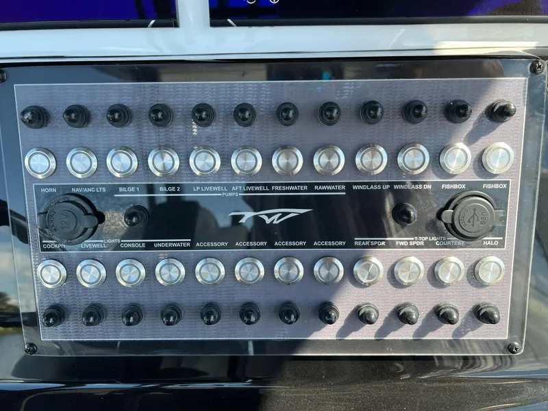 Slide: The Image of Control panel of 2023 Tidewater 320 CC Adventure boat with labeled switches and buttons. - 11