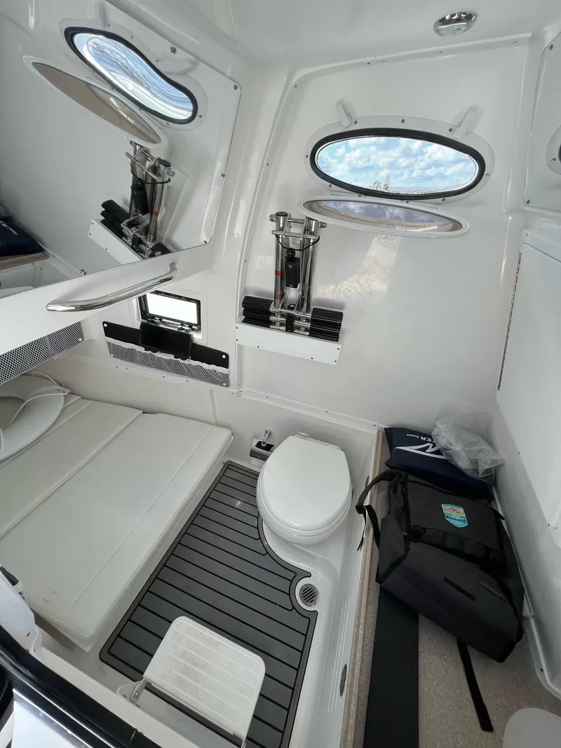 Slide: The Image of 2023 Tidewater 320 CC Adventure boat cabin with toilet and seating area. - 14