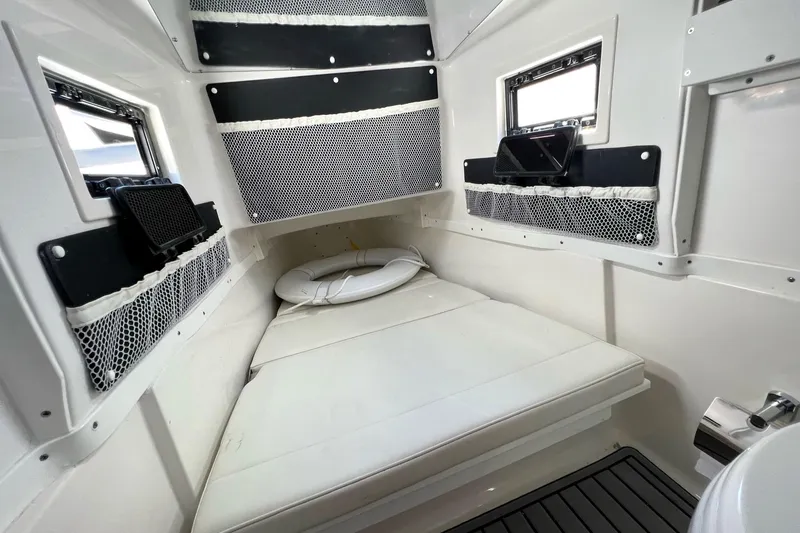 Slide: The Image of 2023 Tidewater 320 CC Adventure cabin interior with cushioned seating and storage nets. - 15
