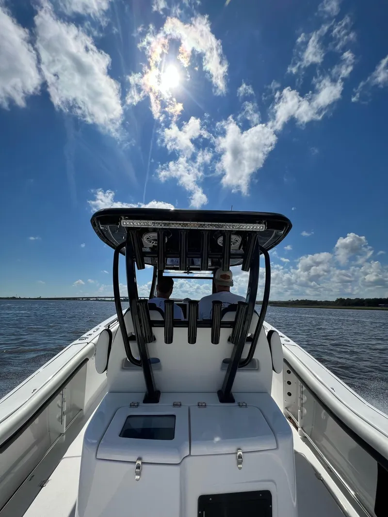 Slide: The Image of 2023 Tidewater 320 CC Adventure boat cruising under a sunny sky. - 16
