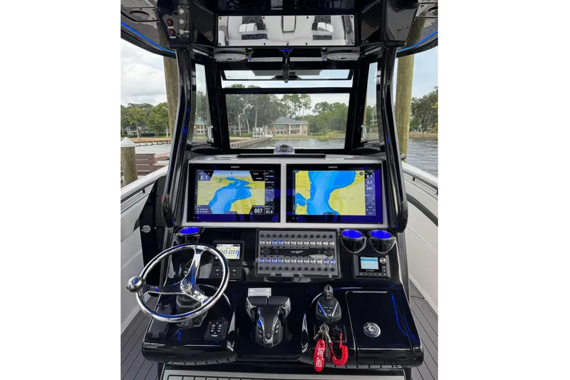 Slide: The Image of 2023 Tidewater 320 CC Adventure boat dashboard with navigation screens and controls. - 2
