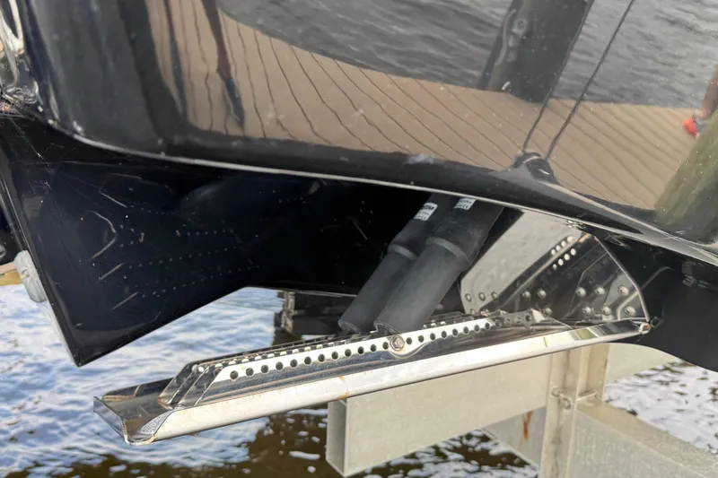 Slide: The Image of Close-up of 2023 Tidewater 320 CC Adventure boat's trim tab and hull detail. - 29