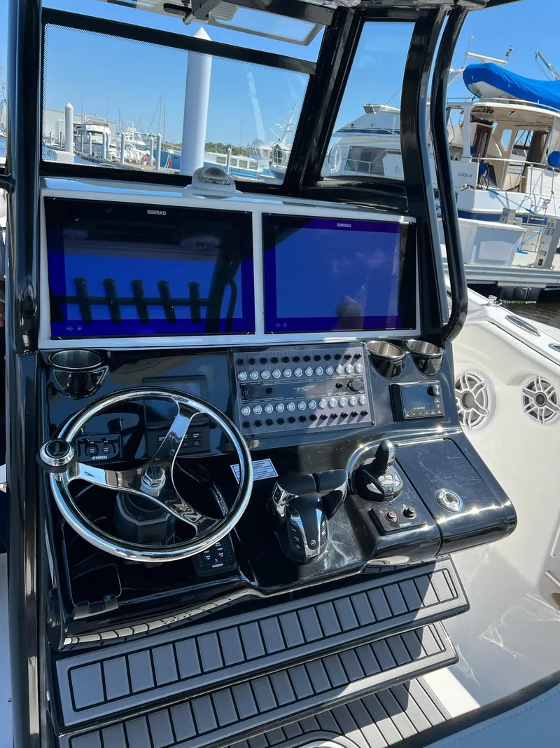 Slide: The Image of Control panel of 2023 Tidewater 320 CC Adventure boat with dual screens and steering wheel. - 8