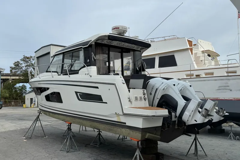 Slide: The Image of 2021 Jeanneau NC Weekender 1095 boat on stands, featuring dual Yamaha outboard engines. - 10