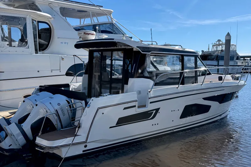 Slide: The Image of 2021 Jeanneau NC Weekender 1095 boat docked with Yamaha engines, under clear blue sky. - 5