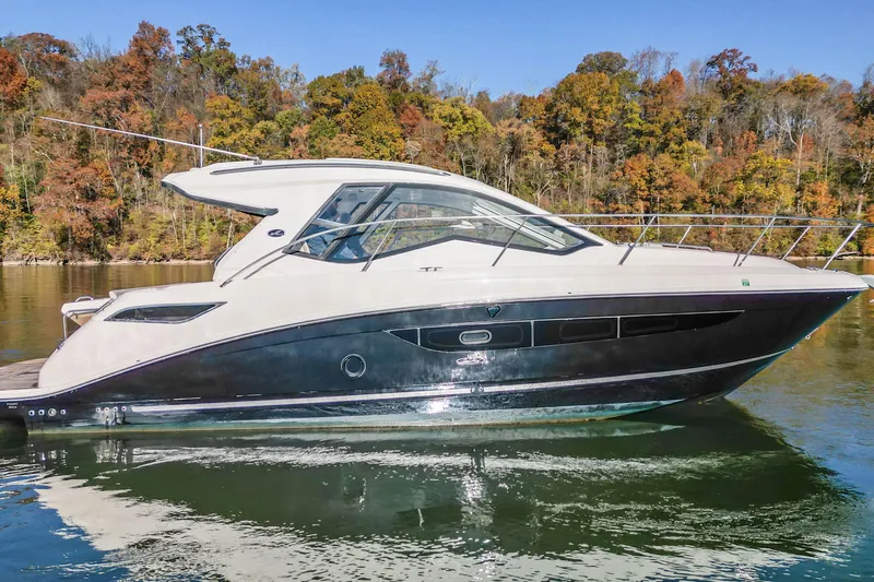Slide: The Image of 2018 Sea Ray Sundancer 350 Coupe on calm water, surrounded by autumn trees. - 4
