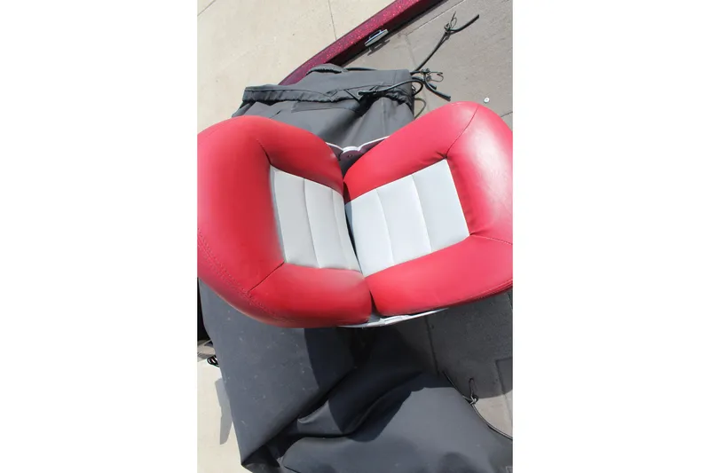 Slide: The Image of Red and gray boat seat from a 2002 Nitro NX 882 DC, on a dock. - 16