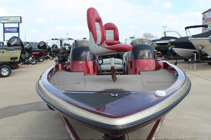 Slide: The Image of 2002 Nitro NX 882 DC boat with red seating, displayed at a dealership. - 2