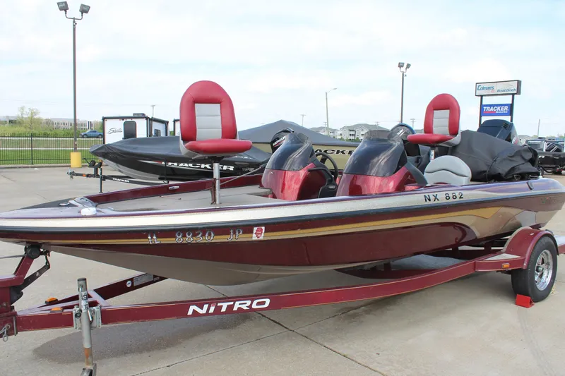 Slide: The Image of 2002 Nitro NX 882 DC boat on trailer, red and white seats, parked outdoors. - 3