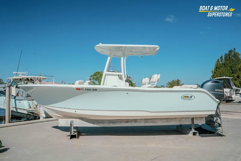 The Image of 2021 Sea Hunt Ultra 229 boat on display at a marina under clear blue skies. - 0