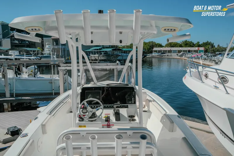 Slide: The Image of 2021 Sea Hunt Ultra 229 boat at marina, featuring helm and rod holders. - 10