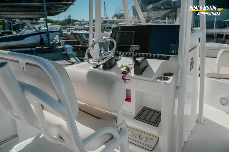 Slide: The Image of 2021 Sea Hunt Ultra 229 boat interior with steering wheel and control panel at marina. - 15