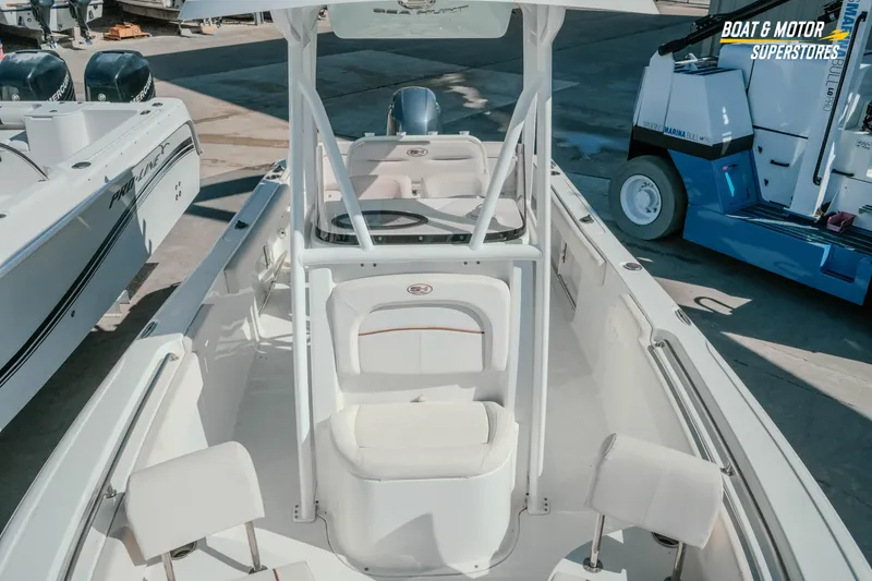 Slide: The Image of 2021 Sea Hunt Ultra 229 boat interior with seating and console, displayed at a marina. - 22