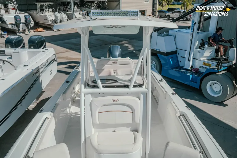 Slide: The Image of 2021 Sea Hunt Ultra 229 boat in a marina, surrounded by other vessels and equipment. - 23