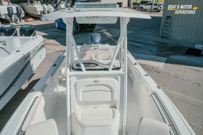 Slide: The Image of 2021 Sea Hunt Ultra 229 boat displayed at dealership with other boats. - 24