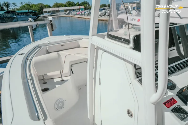 Slide: The Image of 2021 Sea Hunt Ultra 229 boat interior with seating and control panel at marina. - 27