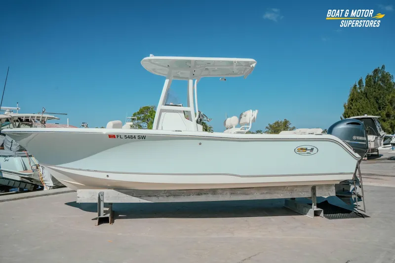 Slide: The Image of 2021 Sea Hunt Ultra 229 boat on display at a marina under clear blue skies. - 31