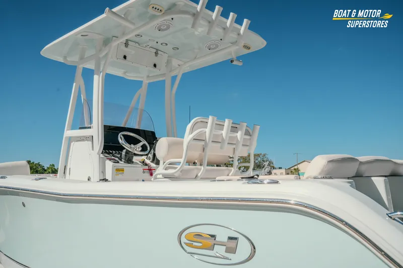 Slide: The Image of 2021 Sea Hunt Ultra 229 boat with T-top and rod holders under clear blue sky. - 33