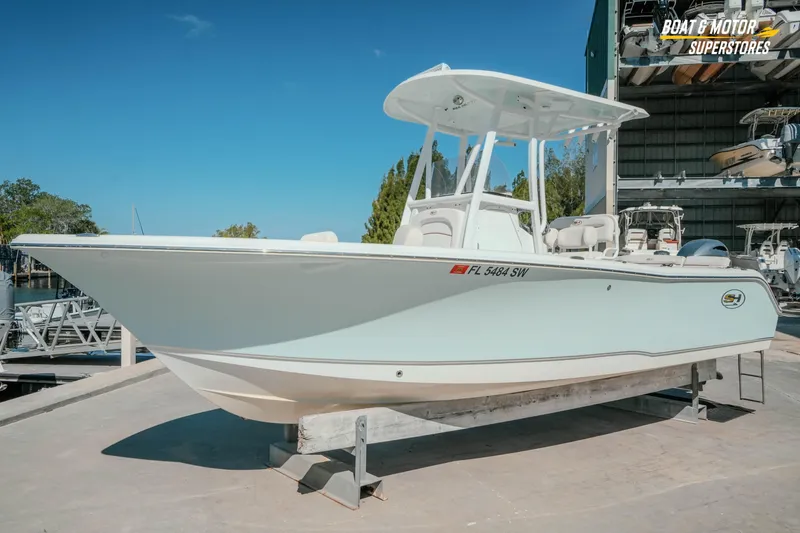 Slide: The Image of 2021 Sea Hunt Ultra 229 boat displayed at a marina under clear blue skies. - 34
