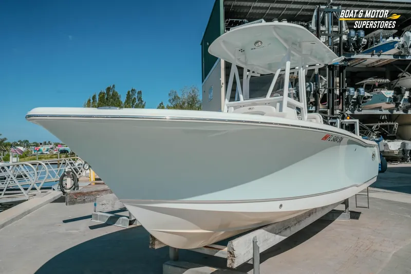 Slide: The Image of 2021 Sea Hunt Ultra 229 boat displayed at a marina under clear blue skies. - 35