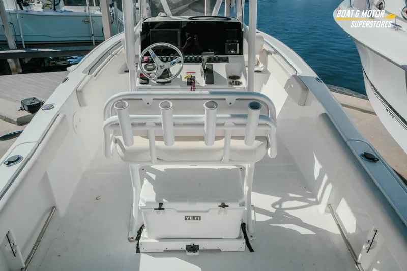 Slide: The Image of 2021 Sea Hunt Ultra 229 boat interior with steering console and rod holders. - 4