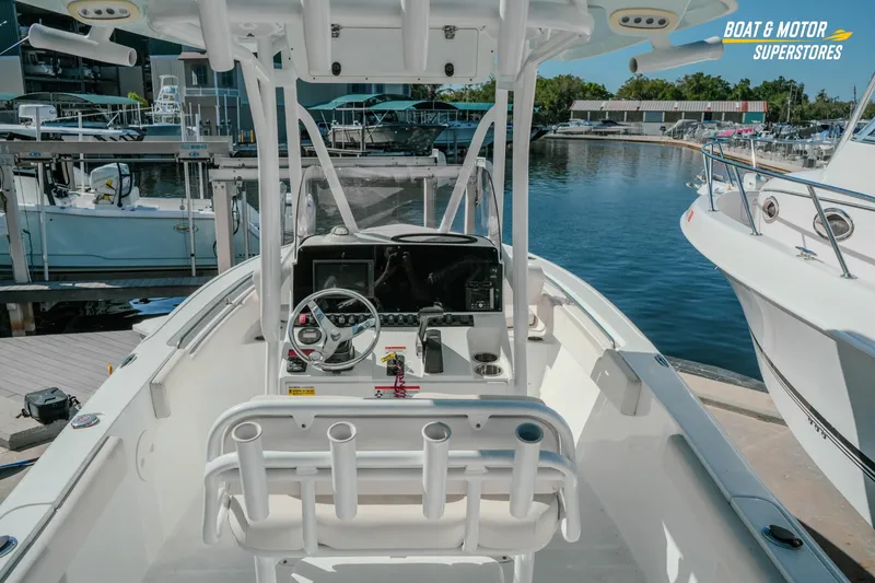 Slide: The Image of 2021 Sea Hunt Ultra 229 boat interior at marina, featuring helm and seating. - 9