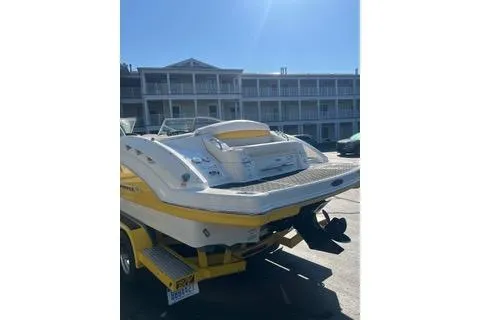 Slide: The Image of 2008 Chaparral Sunesta 224 boat on trailer, parked near a building under clear skies. - 10