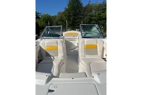 Slide: The Image of 2008 Chaparral Sunesta 224 boat interior with white and yellow seating, clear skies, and trees. - 5