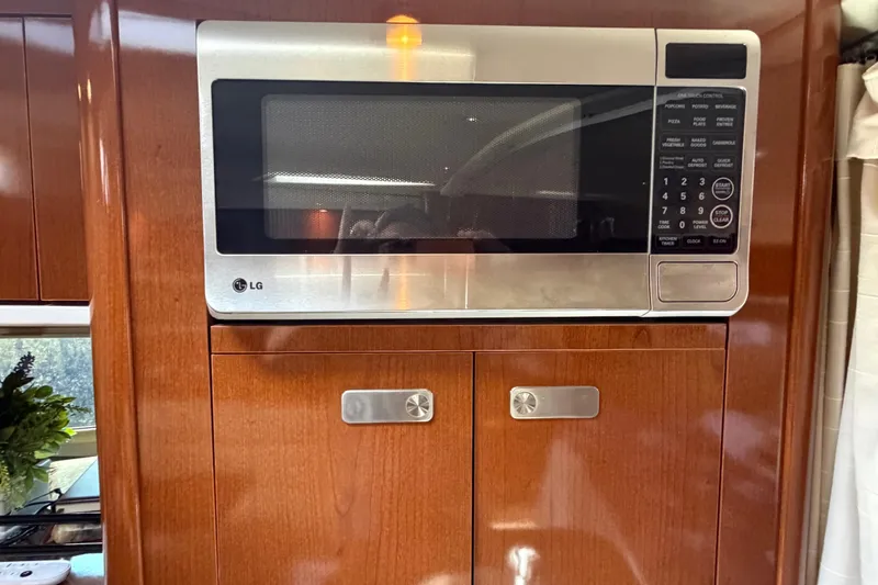 Slide: The Image of LG microwave in 2012 Sea Ray Sundancer 350 yacht kitchen, with wooden cabinetry. - 10