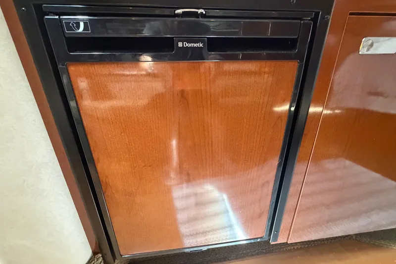 Slide: The Image of Dometic refrigerator in 2012 Sea Ray Sundancer 350 yacht, featuring a sleek wooden finish. - 14