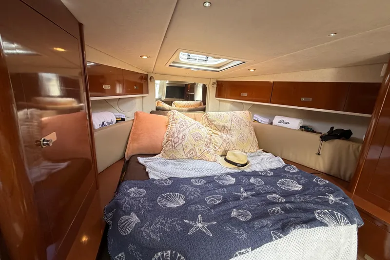 Slide: The Image of Interior cabin of 2012 Sea Ray Sundancer 350 yacht with cozy bedding and wooden cabinetry. - 23