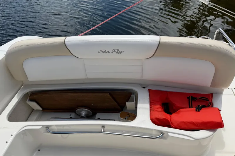 Slide: The Image of 2012 Sea Ray Sundancer 350 boat with open storage compartment and red life jacket. - 25