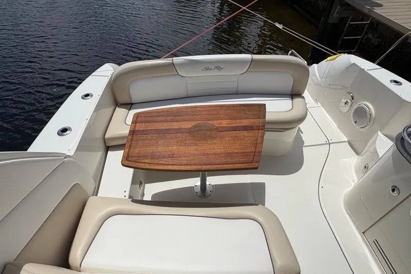 Slide: The Image of 2012 Sea Ray Sundancer 350 boat interior with wooden table and cushioned seating. - 26