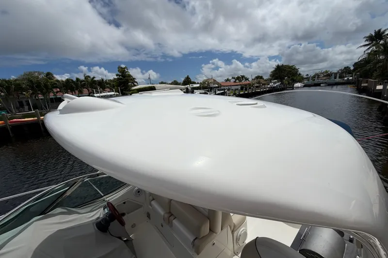 Slide: The Image of 2012 Sea Ray Sundancer 350 boat docked on a sunny day, showcasing sleek design. - 34